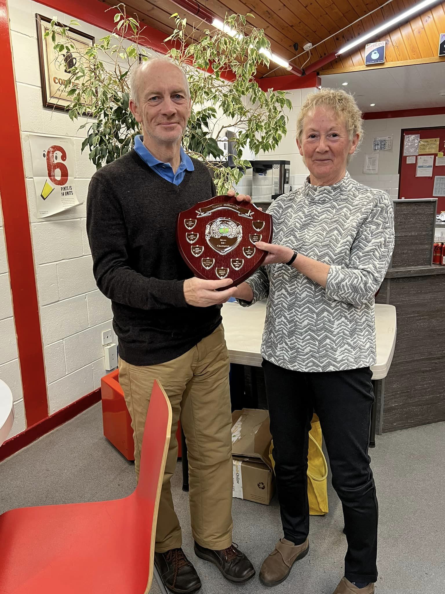 Kevin Heath receives the V60 trophy from Sue Taylor